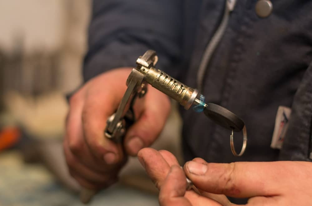 locksmith holding the ignition of a car with a key inside it